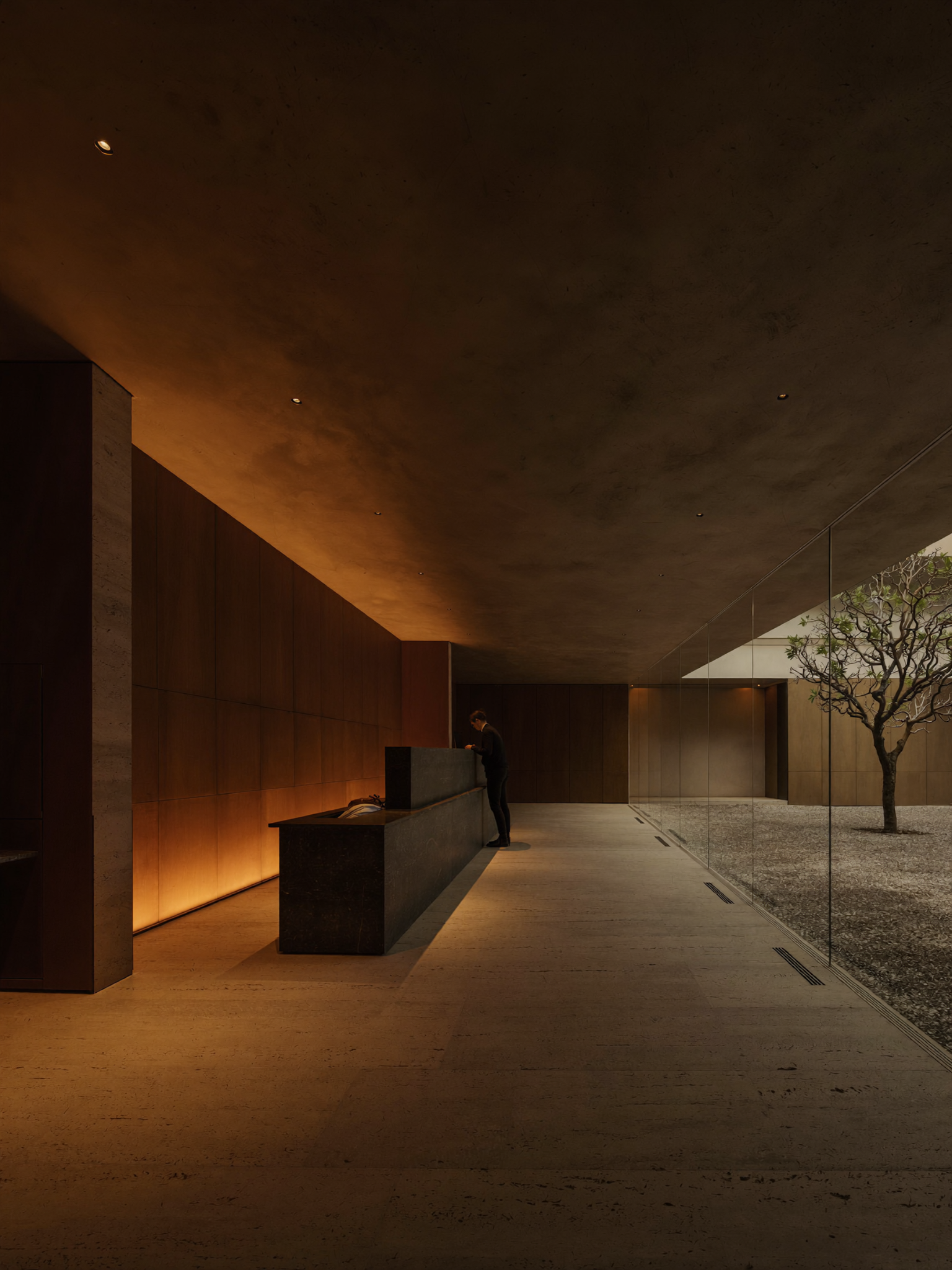 Dunkler warmer Empfangsbereich mit Beton, Holz und indirektem Licht